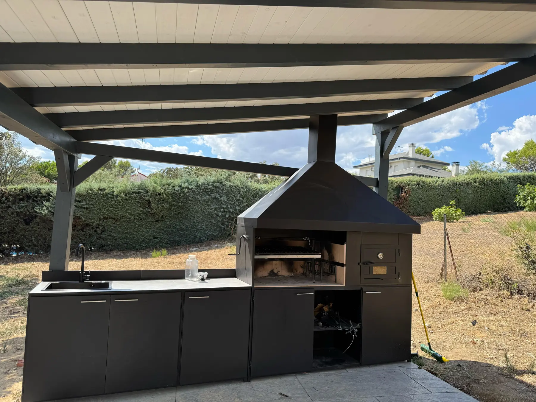 Barbacoa a medida integrada bajo pérgola de madera