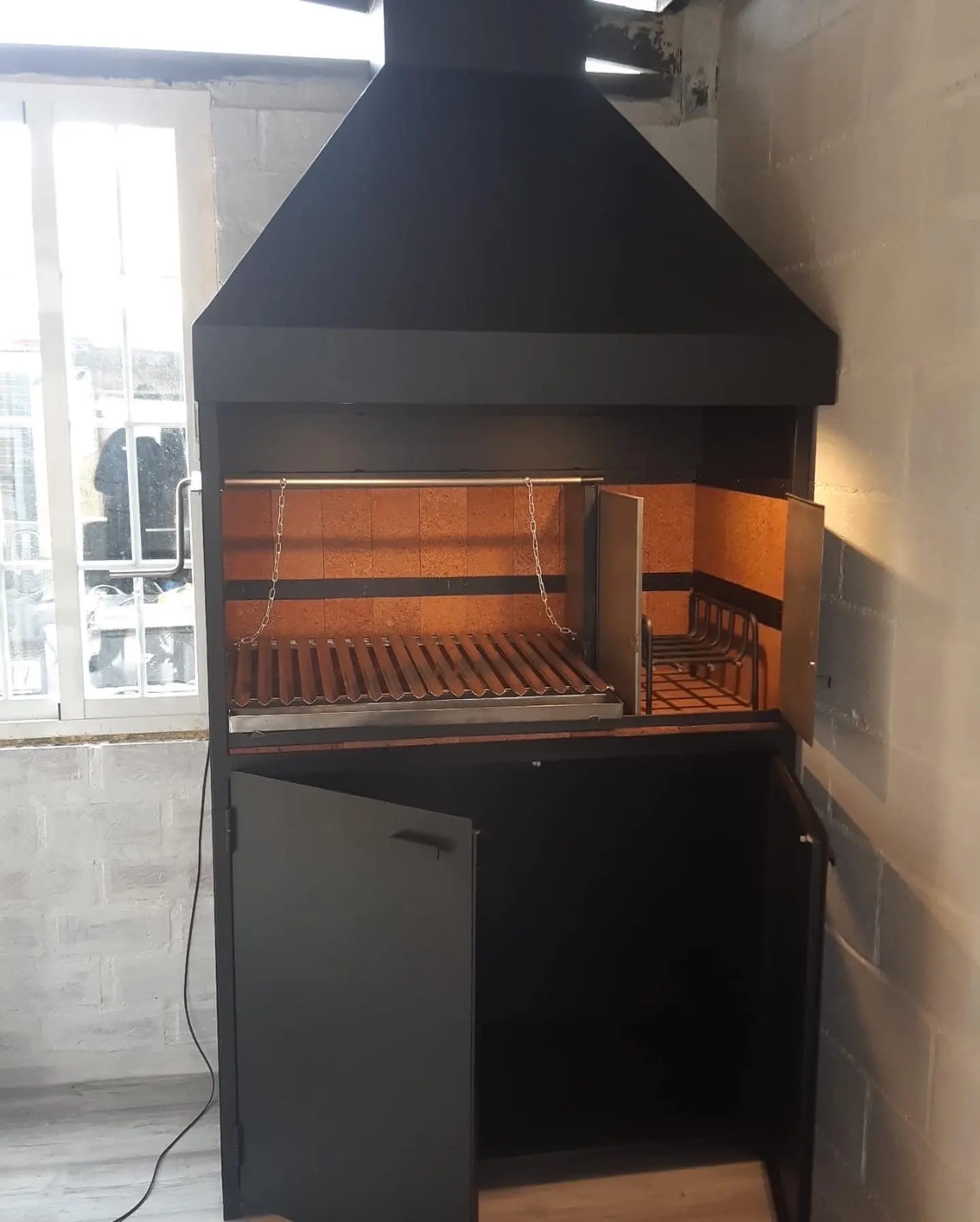 Barbacoa metálica con parrilla regulable en altura