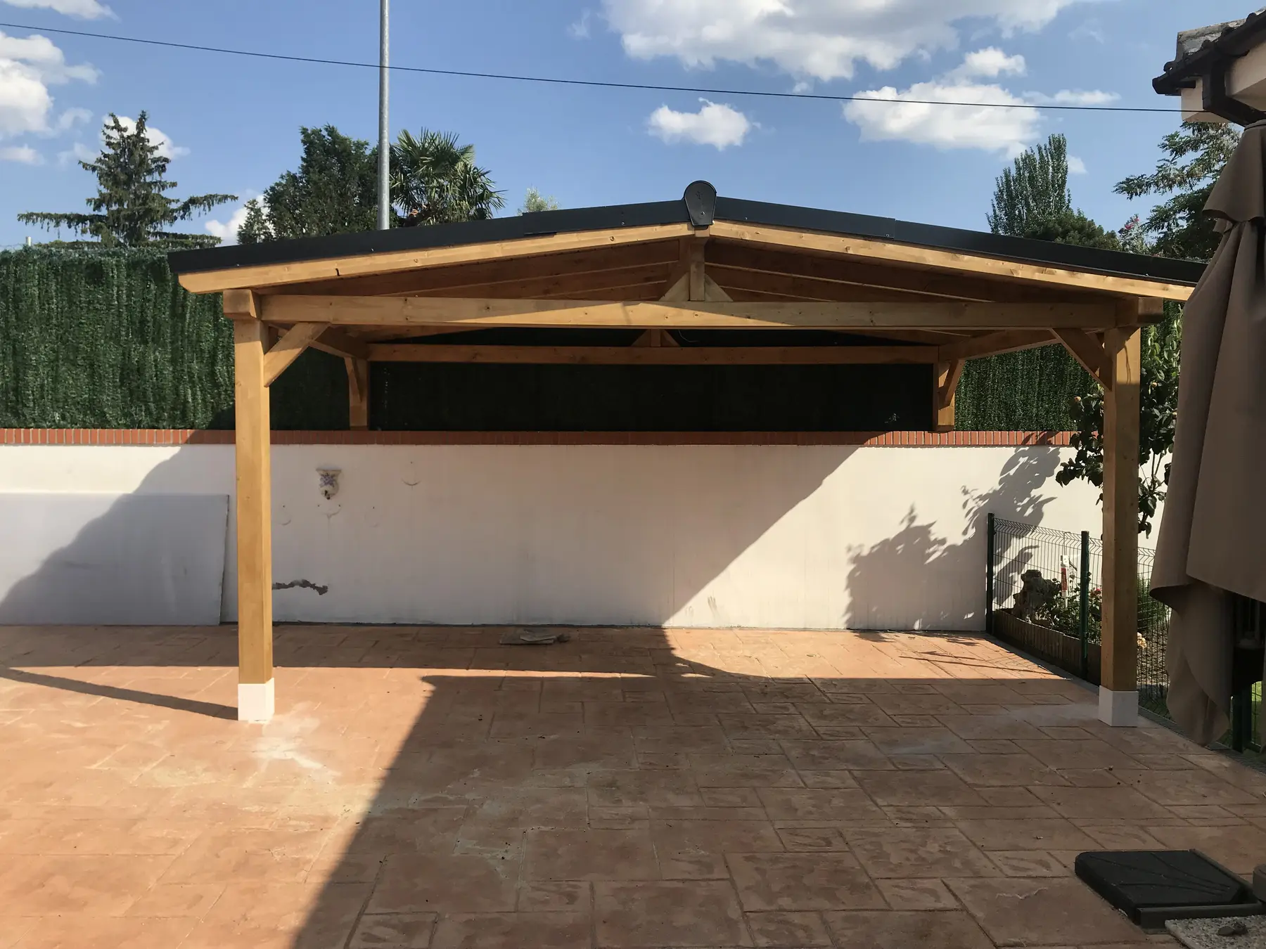 Pérgola garaje de madera junto a vivienda
