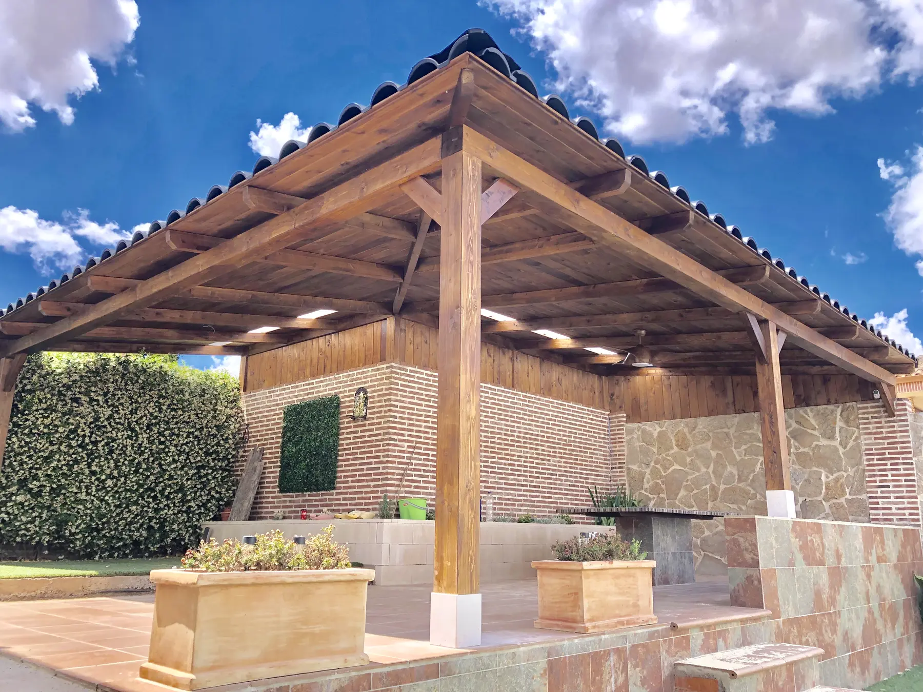 Porche de madera adosado a vivienda de ladrillo con cubierta tradicional