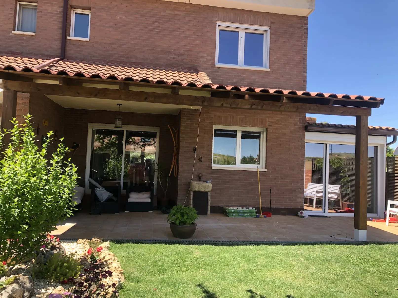 Porche de madera adosado en vivienda con jardín y acceso desde salón